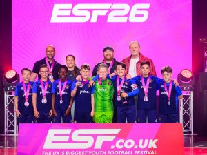 Ebbsfleet United Whites U10s team on stage at ESTF26 football tournament collecting medals
