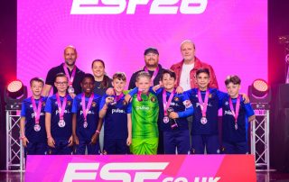 Ebbsfleet United Whites U10s team on stage at ESTF26 football tournament collecting medals