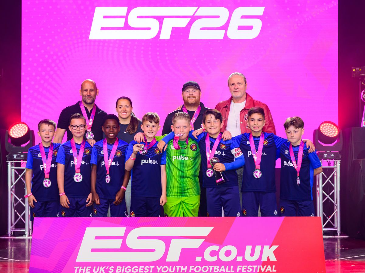 Ebbsfleet United Whites U10s team on stage at ESTF26 football tournament collecting medals