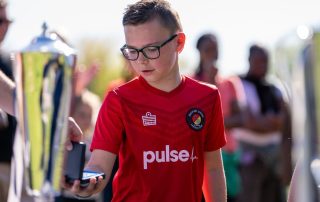 Charlie from the Ebbsfleet United Whites U10s team collecting a medal